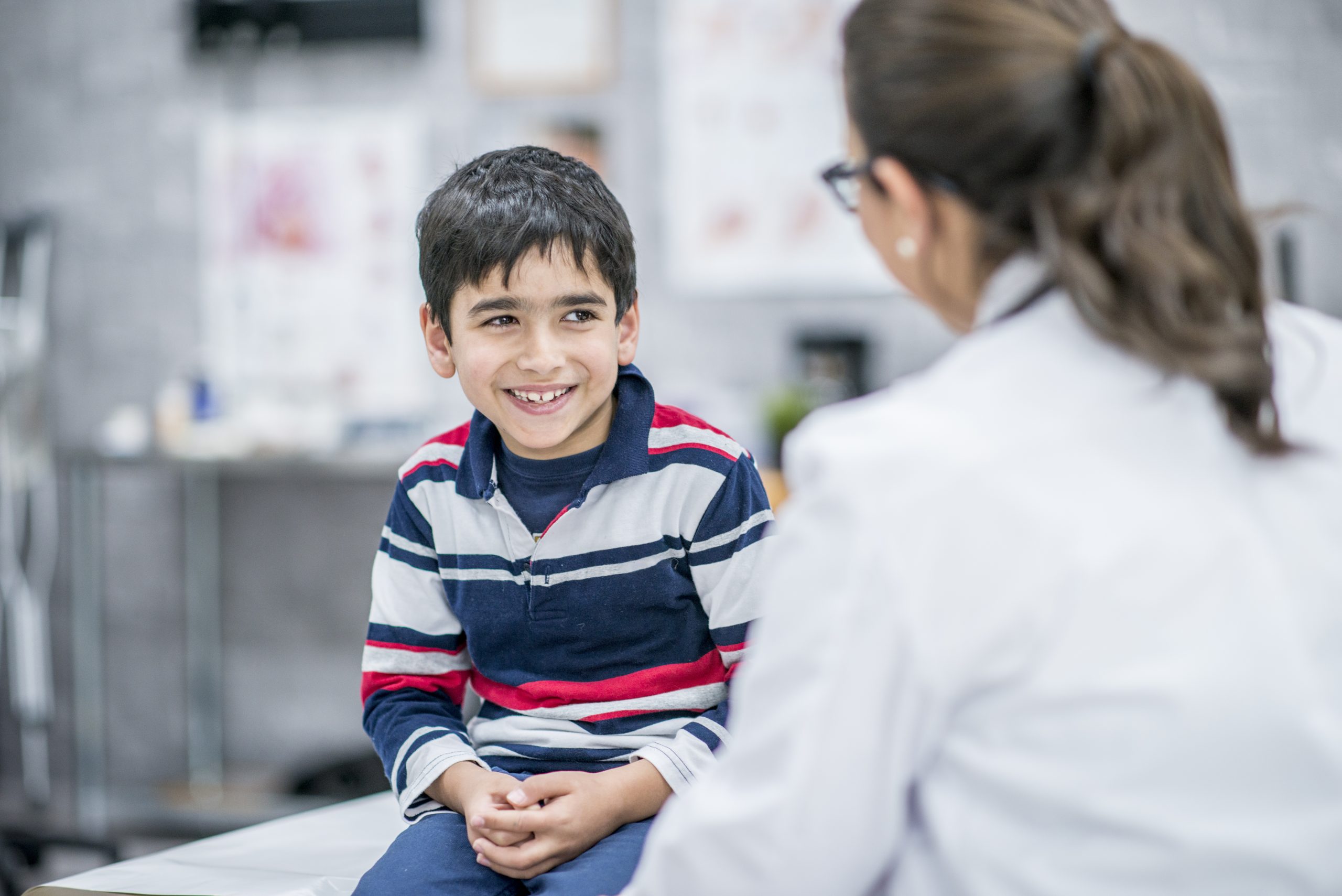 Healthcare professional talking to a young boy.