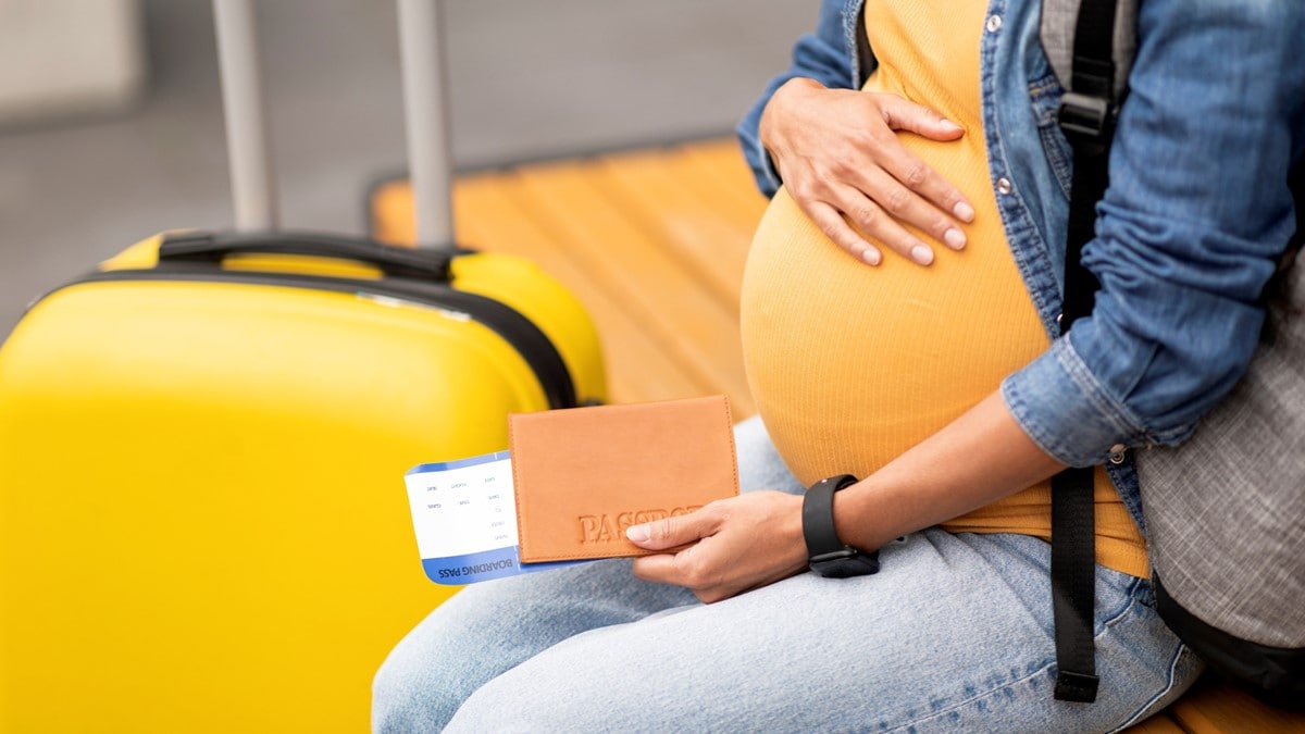 Photo of a pregnant person waiting in the airport before travel abroad.